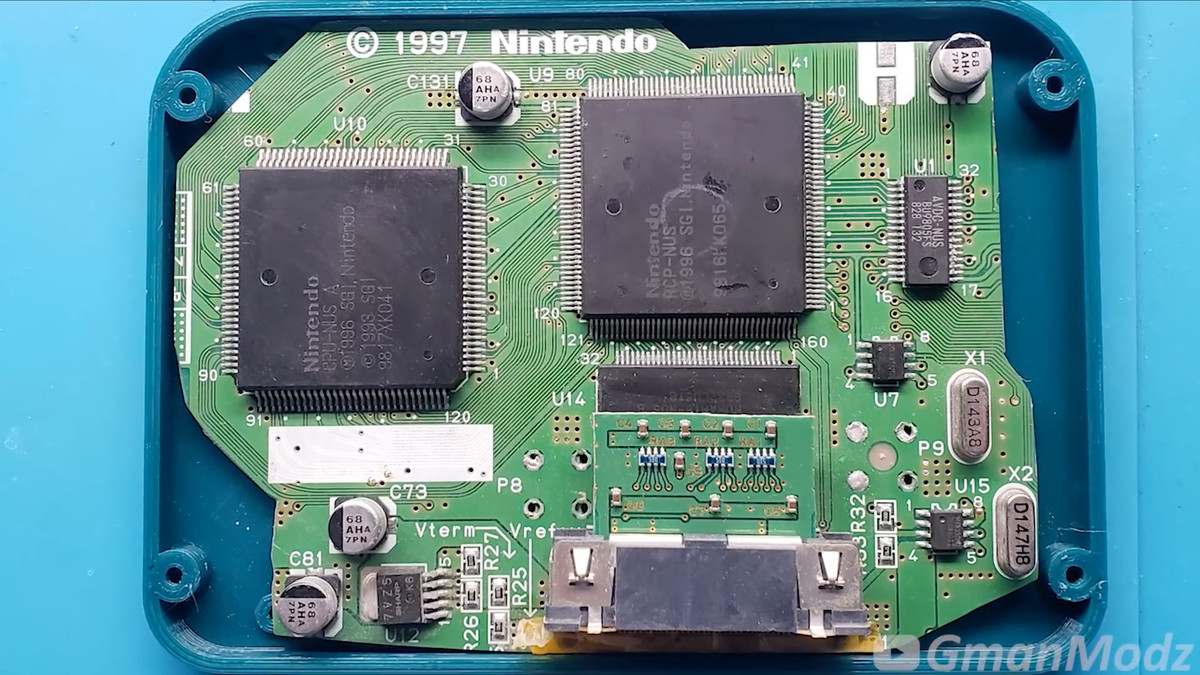 Photo of a Nintendo 64 motherboard seated in a small case.