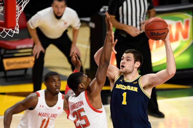 Michigan Center Hunter Dickinson (1) goes to the basket next to Maryland forward Jyeros Hamilton (25) and goalkeeper Daryl Morsell (11) during the first half of the NCAA college basketball game, Thursday December 31, 2020, in College Park, MD.