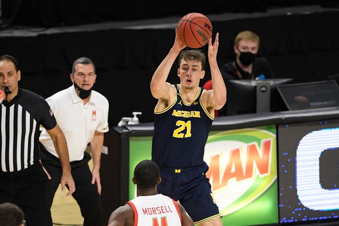 Michigan goalkeeper Franz Wagner (21) controls the ball against Maryland goalkeeper Daryl Morsell, ahead, during the first half of the NCAA college basketball game, Thursday December 31, 2020, in College Park, Maryland.
